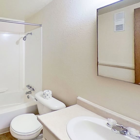 Thumbnail 13 of 19 a bathroom with a sink toilet and a bathtub/shower combination at Normandy Village Apartments, Michigan City, Indiana