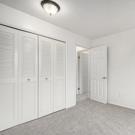 Thumbnail 17 of 19 an empty bedroom with white closet doors at Normandy Village Apartments, Michigan City, IN