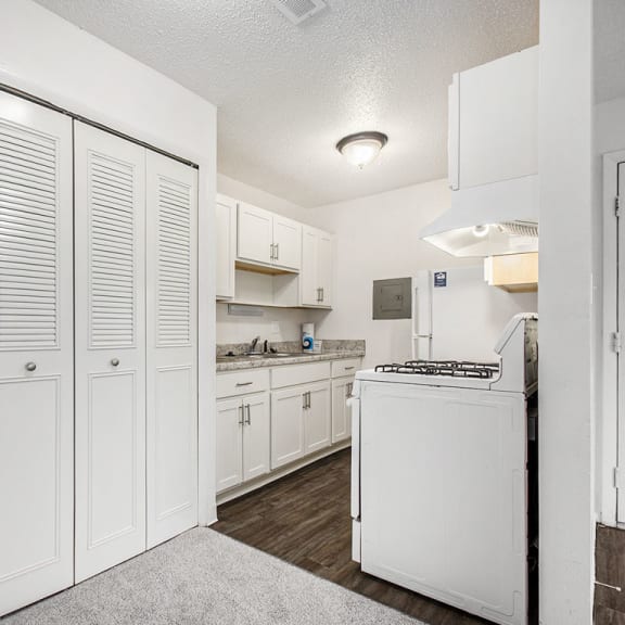 Thumbnail 11 of 19 a white kitchen with white cabinets and white appliances at Normandy Village Apartments, Michigan City, IN, 46360