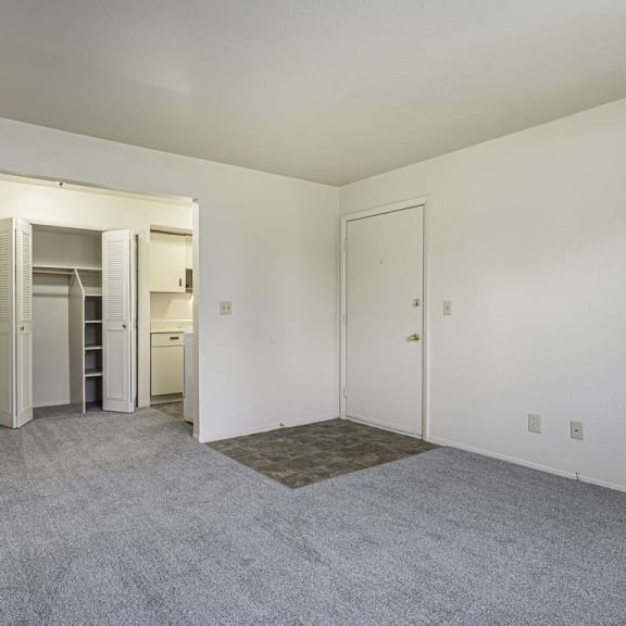 Thumbnail 8 of 19 a living and dining room with a closet and carpet at Normandy Village Apartments, Michigan City, IN, 46360