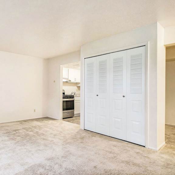 Thumbnail 6 of 8 A living area with a large closet and a carpeted floor at Normandy Village Apartments, Michigan City, 46360