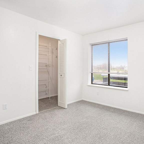 Thumbnail 10 of 10 A bedroom with a large window and a walk-in closet at North Pointe Apartments, Elkhart, IN, 46514