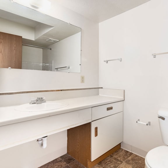 Thumbnail 8 of 9 a bathroom with a toilet sink and a mirror  at Oak Shores Apartments, Oak Creek, 53154