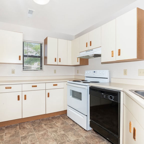 Thumbnail 6 of 11 a kitchen with white cabinets and a stove and a oven  at Oak Shores Apartments, Oak Creek, Wisconsin