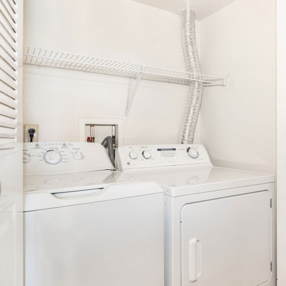 Thumbnail 7 of 11 a white washer and dryer in a laundry room with a white closet  at Oak Shores Apartments, Oak Creek, WI