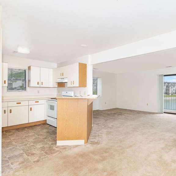 Thumbnail 5 of 11 an empty room with a kitchen and a window  at Oak Shores Apartments, Oak Creek, 53154