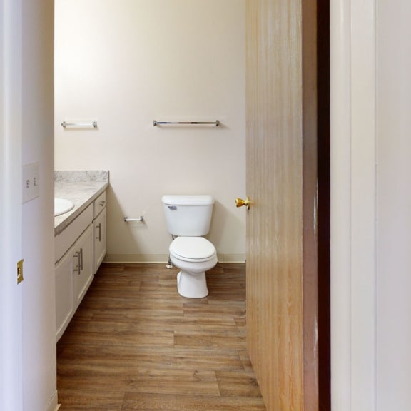 Thumbnail 7 of 9 an empty bathroom with a toilet and a sink  at Oak Shores Apartments, Oak Creek, WI