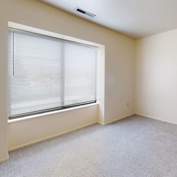 Thumbnail 9 of 9 an empty bedroom with a large window and carpeting  at Oak Shores Apartments, Oak Creek, 53154