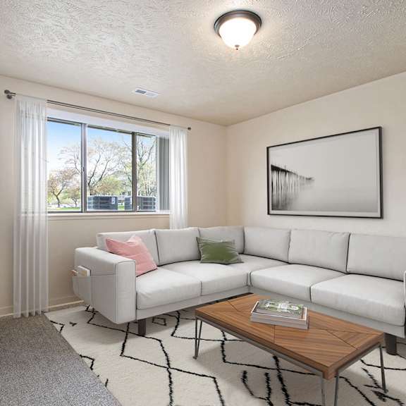 Thumbnail 3 of 12 A garden style living room with a white couch, a coffee table, and a large window at Old Farm Apartments, Elkhart, 46517