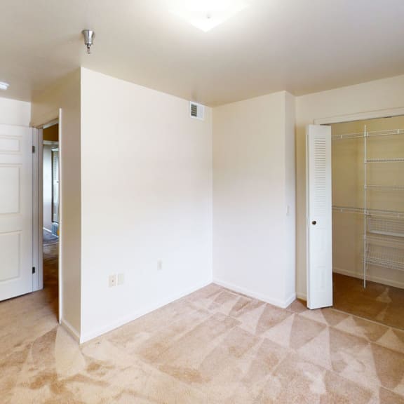 Thumbnail 8 of 12 an empty room with a closet and a door to a bathroom at Orchard Lakes Apartments, Toledo, OH