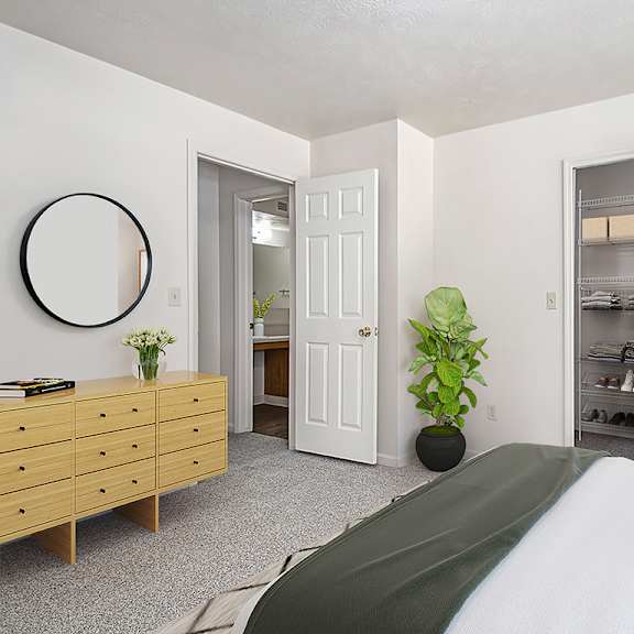 Thumbnail 8 of 9 A bedroom with a bed, dresser, and a walk-in closet with organizers at Orchard Lakes Apartments, Toledo, 43615