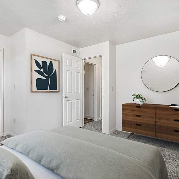 Thumbnail 7 of 10 A bedroom with a grey bed and a walk-in closet with organizers at Orchard Lakes Apartments, Toledo, 43615