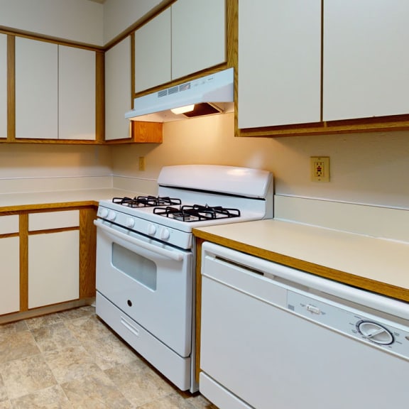 Thumbnail 4 of 7 a kitchen with white appliances and white cabinets at Pine Knoll Apartments, Battle Creek, MI, 49014