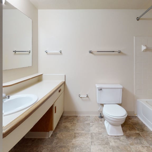 Thumbnail 5 of 8 a bathroom with a toilet and a sink and a tub at Pine Knoll Apartments, Michigan, 49014