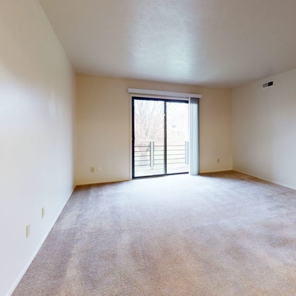 Thumbnail 3 of 8 an empty living room with a door to a balcony at Pine Knoll Apartments, Michigan, 49014