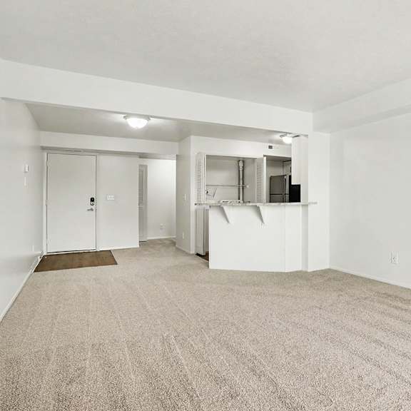 Thumbnail 8 of 17 A dining room with a carpeted floor and a breakfast bar at Pine Knoll Apartments, Battle Creek