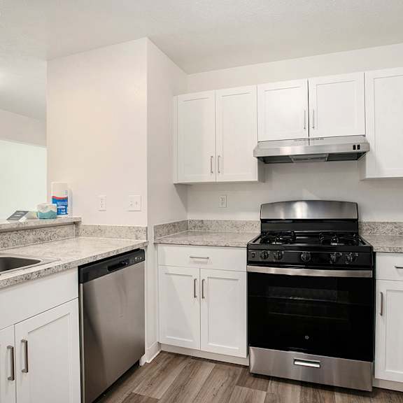 Thumbnail 7 of 17 A kitchen with white cabinets and stainless steel appliances at Pine Knoll Apartments, Battle Creek, 49014