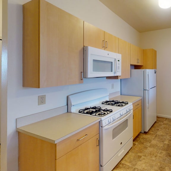 Thumbnail 9 of 18 a kitchen with a stove microwave and sink  at Hunters Pond Apartment Homes, Champaign, IL