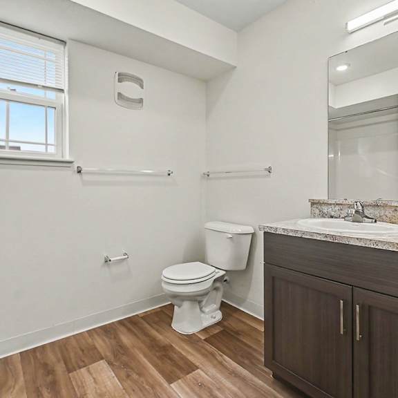 Thumbnail 10 of 12 A bathroom with a window, toilet, sink, and hard-surface flooring at The Reserve at The Reserve at Destination Pointe in Grimes, IA 50111
