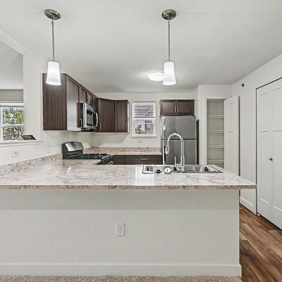 Thumbnail 7 of 12 A kitchen with a breakfast bar and a window at The Reserve at The Reserve at Destination Pointe in Grimes, IA 50111