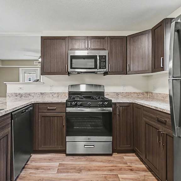 Thumbnail 8 of 12 A kitchen with a stainless steel dishwasher and a stove top oven at The Reserve at The Reserve at Destination Pointe in Grimes, IA 50111
