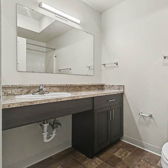 Thumbnail 14 of 16 A bathroom with a toilet, sink, and mirror at The Reserve at The Reserve at Destination Pointe in Grimes, IA 50111
