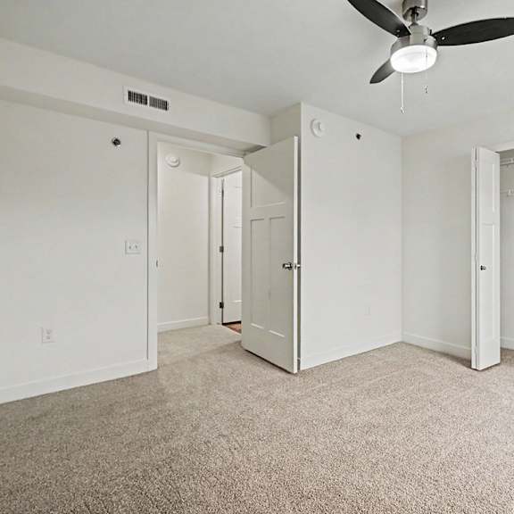 Thumbnail 16 of 16 A bedroom with a ceiling fan and a walk-in closet with wardrobe organizers at The Reserve at The Reserve at Destination Pointe in Grimes, IA 50111