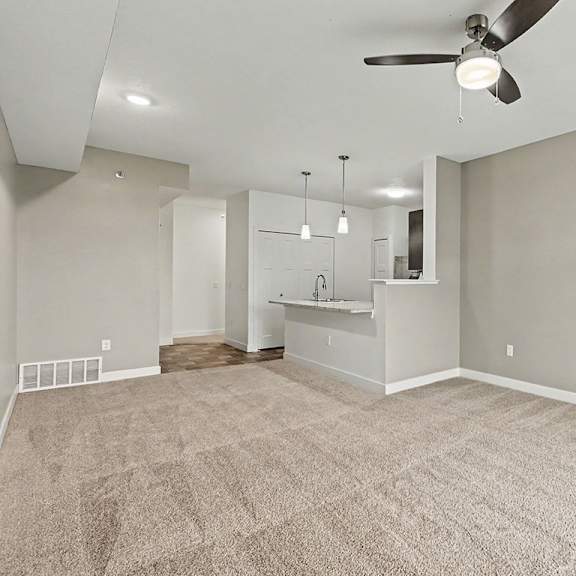 Thumbnail 7 of 16 A spacious dining room with a carpeted floor and a ceiling fan at The Reserve at The Reserve at Destination Pointe in Grimes, IA 50111