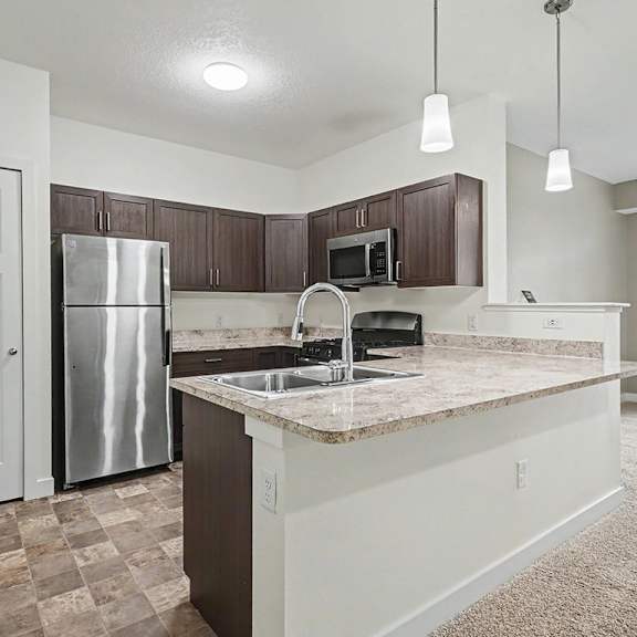 Thumbnail 9 of 16 A kitchen with a pantry, refrigerator, microwave, oven and dishwasher at The Reserve at The Reserve at Destination Pointe in Grimes, IA 50111