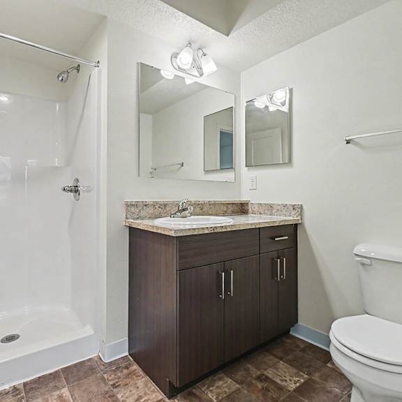 Thumbnail 16 of 16 A bathroom with a shower, toilet, sink, and mirror at The Reserve at The Reserve at Destination Pointe in Grimes, IA 50111