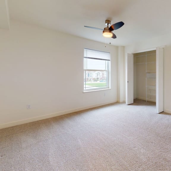 Thumbnail 7 of 7 an empty living room with a ceiling fan and a closet at The Reserve at Destination Pointe, Grimes
