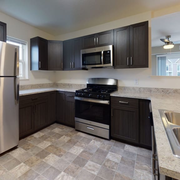 Thumbnail 5 of 7 a kitchen with stainless steel appliances and black cabinetsat The Reserve at Destination Pointe, Grimes