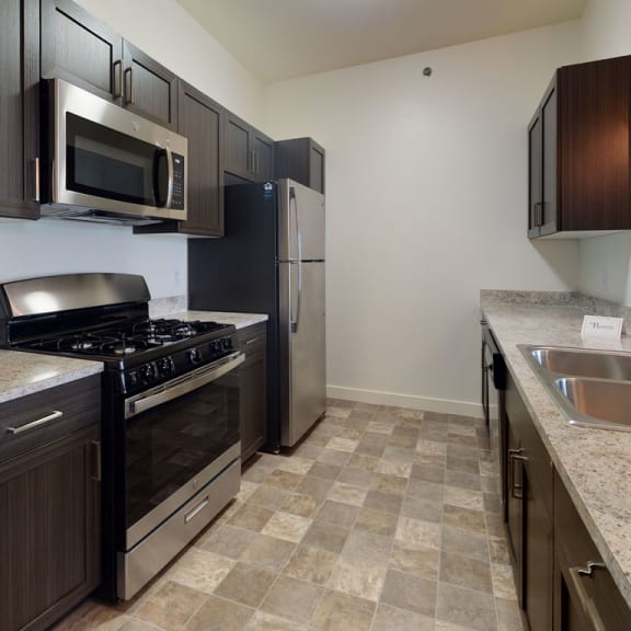Thumbnail 5 of 10 a kitchen with stainless steel appliances and marble counter topsat The Reserve Apartment Homes in Grimes, Iowa