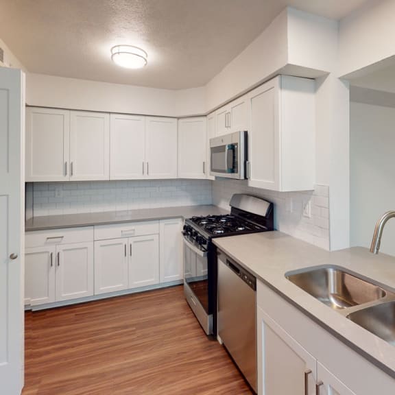 Thumbnail 6 of 10 an empty kitchen with white cabinets and a sink at Green Ridge Apartments, Michigan, 49544