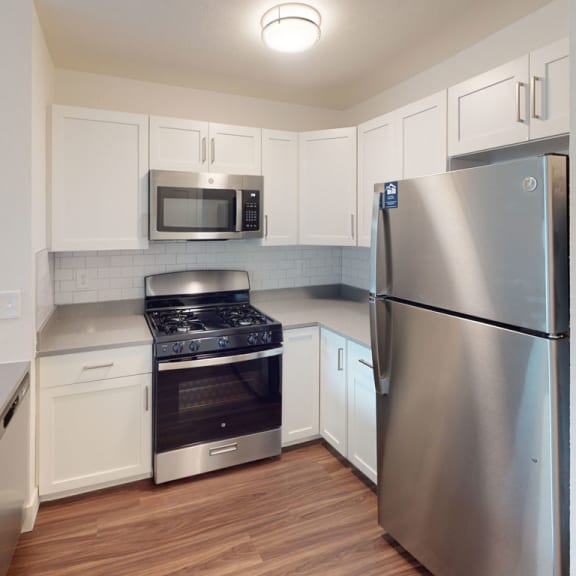 Thumbnail 7 of 14 a kitchen with white cabinets and hard surface flooring at Green Ridge Apartments, Grand Rapids, MI, 49544