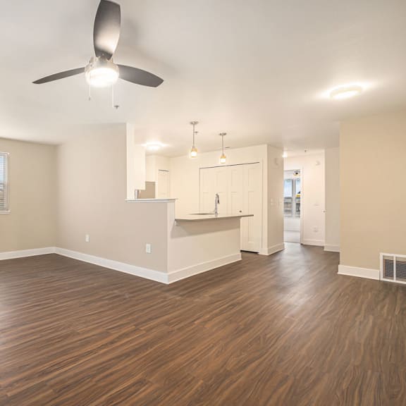 Thumbnail 7 of 12 a spacious living room and kitchen with a ceiling fan  at Signature Pointe Apartment Homes, Athens