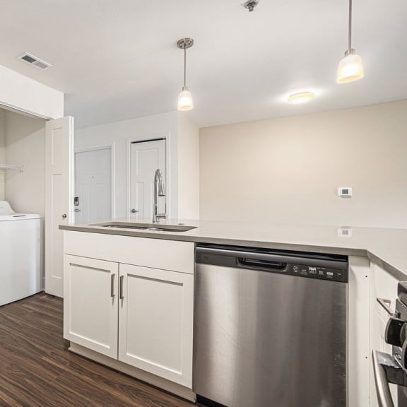 Thumbnail 9 of 14 a kitchen with a full-size washer and dryer  at Signature Pointe Apartment Homes, Athens, AL, 35611