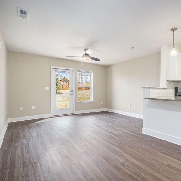 Thumbnail 6 of 14 living room and kitchen with a door to a private patio  at Signature Pointe Apartment Homes, Alabama
