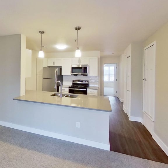 Thumbnail 11 of 22 living room leading into a kitchen at Signature Pointe Apartment Homes in Athens, AL