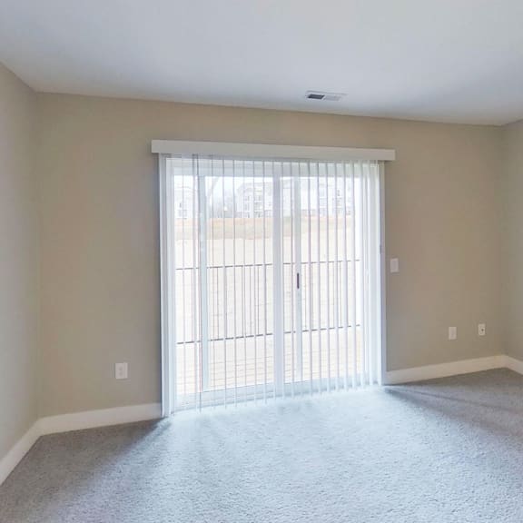 Thumbnail 9 of 22 living room with a slider to a private balcony at Signature Pointe Apartment Homes in Athens, AL