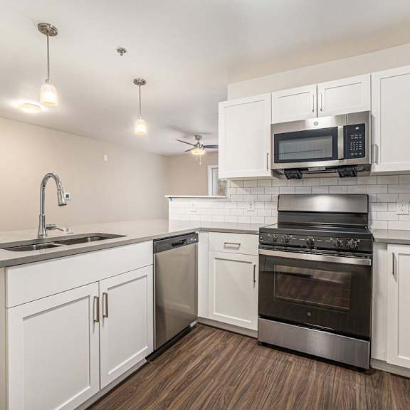 Thumbnail 8 of 14 A kitchen with white cabinets and a stainless steel oven at Signature Pointe Apartment Homes, Athens, 35611