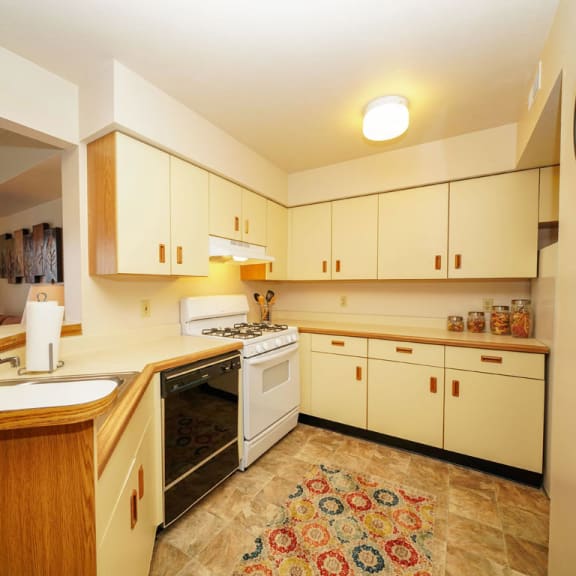 Thumbnail 8 of 11 a kitchen with white cabinets and a stove and a sink at South Bridge Apartments, Fort Wayne, IN