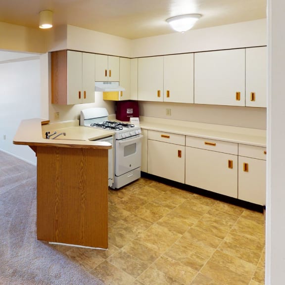 Thumbnail 5 of 11 a kitchen and living room with white cabinets and a counter at South Bridge Apartments, Fort Wayne