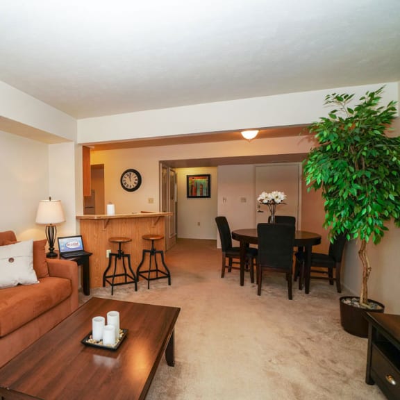 Thumbnail 6 of 11 a living room and dining room with a couch and a table at South Bridge Apartments, Indiana, 46816