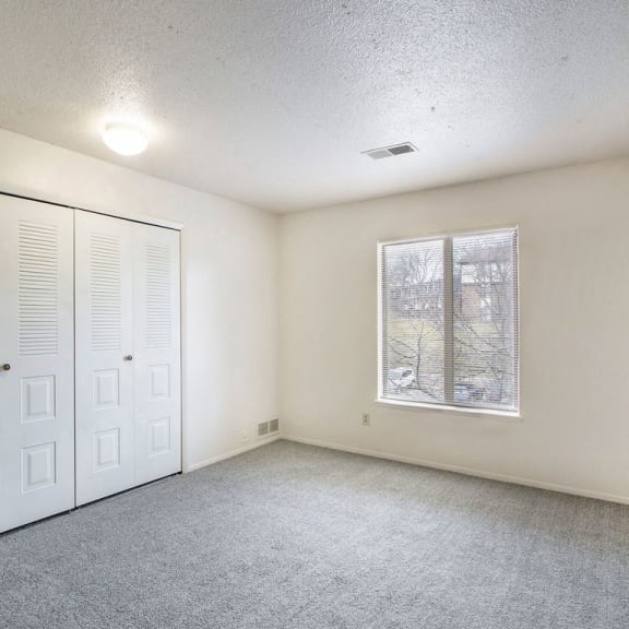 Thumbnail 5 of 6 an empty living room with a window and a closet at South Bridge Apartments, Fort Wayne, IN