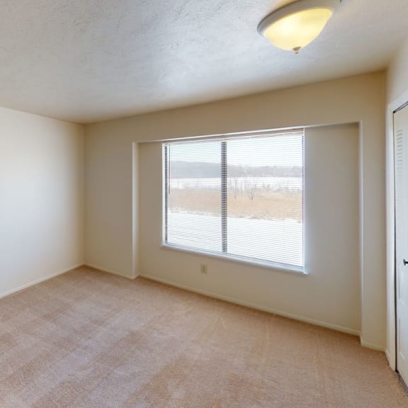 Thumbnail 8 of 8 an empty bedroom with a large window at South Bridge Apartments, Indiana