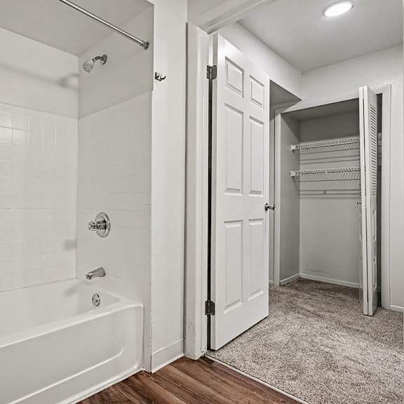 Thumbnail 18 of 24 A white bathroom with a walk-in shower and a white door.