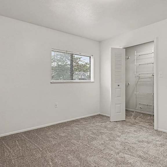 Thumbnail 21 of 24 A room with a carpeted floor and a window with blinds.