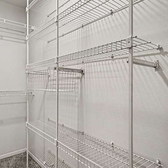 Thumbnail 23 of 24 A white walk in closet with shelves and hooks.