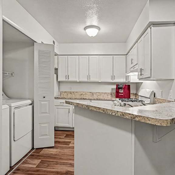 Thumbnail 9 of 24 A kitchen with white cabinets and a marble countertop.